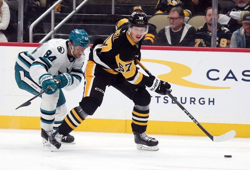 Nov 16, 2024; Pittsburgh, Pennsylvania, USA;  Pittsburgh Penguins right wing Rickard Rakell (67) moves the puck against San Jose Sharks defenseman Jan Rutta (84) during the third period at PPG Paints Arena. Mandatory Credit: Charles LeClaire-Imagn Images