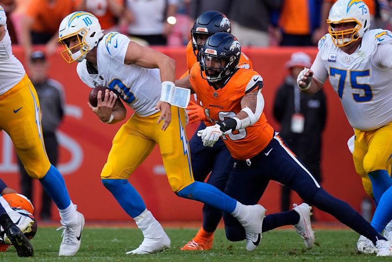 Los Angeles Chargers quarterback Justin Herbert (10) is sacked by Denver Broncos linebacker Justin Strnad (40) during the second half of an NFL football game, Sunday, Oct. 13, 2024, in Denver. (AP Photo/David Zalubowski)