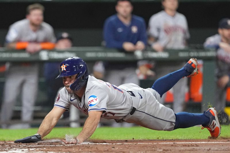 Aug 22, 2024; Baltimore, Maryland, USA; Houston Astros second baseman Jose Altuve (27) slides in safely to score during the fourth inning against the Baltimore Orioles at Oriole Park at Camden Yards. Mandatory Credit: Mitch Stringer-USA TODAY Sports