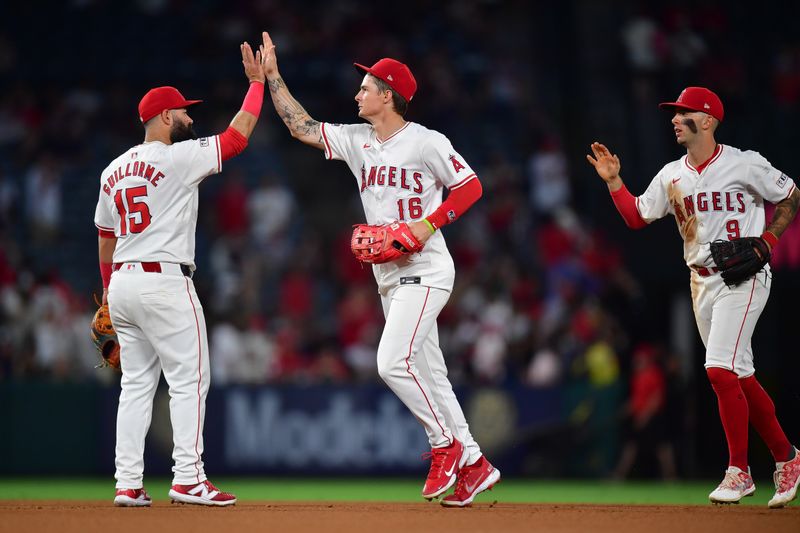 Jun 27, 2024; Anaheim, California, USA; Los Angeles Angels second base Luis Guillorme (15) center fielder Mickey Moniak (16) and shortstop Zach Neto (9) celebrate the victory at Angel Stadium. Mandatory Credit: Gary A. Vasquez-USA TODAY Sports
