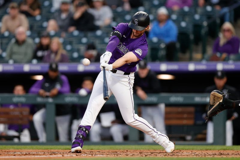 Apr 22, 2024; Denver, Colorado, USA; Colorado Rockies third baseman Ryan McMahon (24) hits a sacrifice fly RBI in the fourth inning against the San Diego Padres at Coors Field. Mandatory Credit: Isaiah J. Downing-USA TODAY Sports