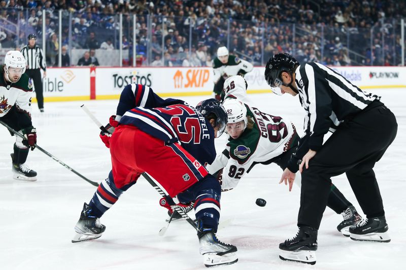 Nov 18, 2023; Winnipeg, Manitoba, CAN;  Winnipeg Jets forward Mark Scheifele (55) faces off against Arizona Coyotes forward Logan Cooley (92) during the first period at Canada Life Centre. Mandatory Credit: Terrence Lee-USA TODAY Sports