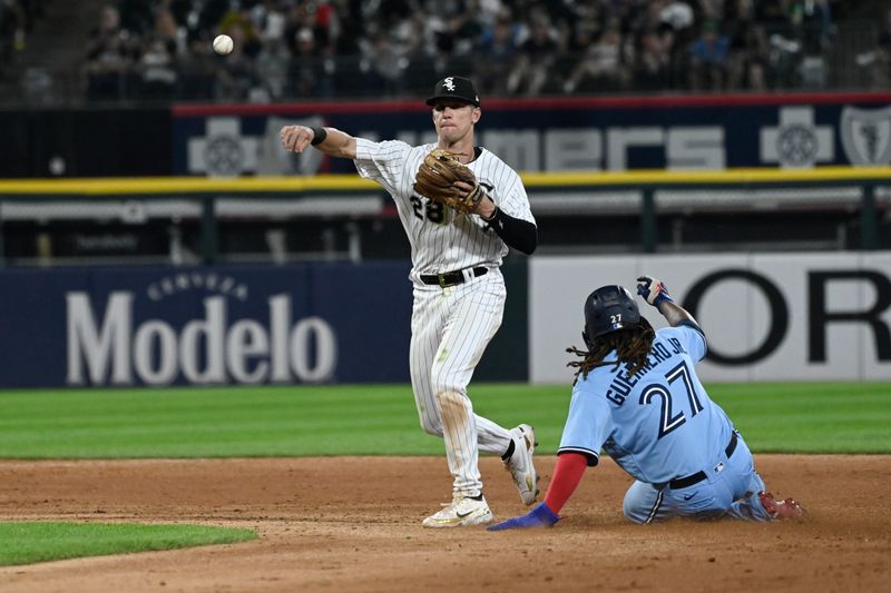 Jul 6, 2023; Chicago, Illinois, USA;Chicago White Sox shortstop Zach Remillard (28) throws to first base after forcing Toronto Blue Jays first baseman Vladimir Guerrero Jr. (27) out at second during the fifth inning at Guaranteed Rate Field. Mandatory Credit: Matt Marton-USA TODAY Sports