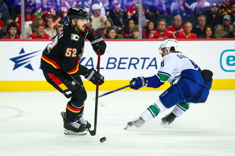 Dec 31, 2024; Calgary, Alberta, CAN; Calgary Flames defenseman MacKenzie Weegar (52) controls the puck against Vancouver Canucks right wing Conor Garland (8) during the third period at Scotiabank Saddledome. Mandatory Credit: Sergei Belski-Imagn Images