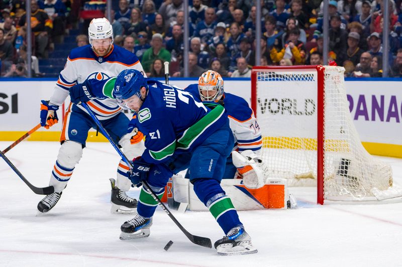 May 8, 2024; Vancouver, British Columbia, CAN; Edmonton Oilers defenseman Brett Kulak (27) watches Vancouver Canucks forward Nils Hoglander (21) handle the puck during the first period in game one of the second round of the 2024 Stanley Cup Playoffs at Rogers Arena. Mandatory Credit: Bob Frid-USA TODAY Sports