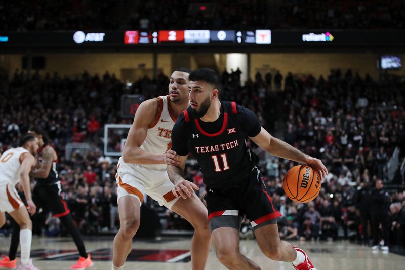 Feb 13, 2023; Lubbock, Texas, USA;  Texas Tech Red Raiders forward Fardaws Aimaq (11) dribbles the ball against Texas Longhorns forward Dylan Disu (1) in the first half at United Supermarkets Arena. Mandatory Credit: Michael C. Johnson-USA TODAY Sports