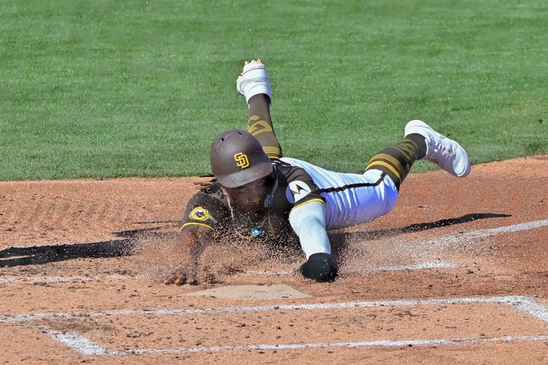 Mar 1, 2024; Peoria, Arizona, USA; San Diego Padres third baseman Eguy Rosario (5) slides and scores in the second inning against the Los Angeles Angels during a spring training game at Peoria Sports Complex. Mandatory Credit: Matt Kartozian-USA TODAY Sports