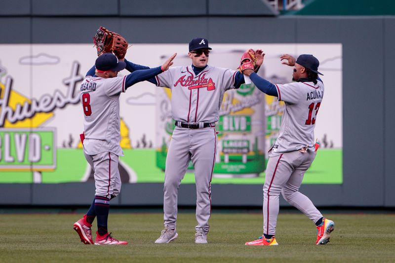 Apr 16, 2023; Kansas City, Missouri, USA; Atlanta Braves left fielder Eddie Rosario (8) Atlanta Braves right fielder Ronald Acuna Jr. (13) and Atlanta Braves center fielder Sam Hilliard (14) high five in center field after the game against the Kansas City Royals at Kauffman Stadium. Mandatory Credit: William Purnell-USA TODAY Sports