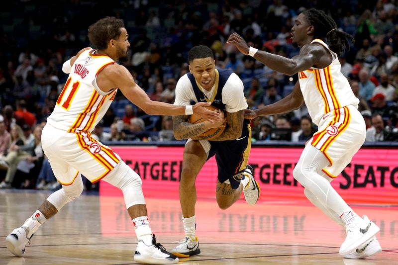 NEW ORLEANS, LOUISIANA - NOVEMBER 03: Jordan Hawkins #24 of the New Orleans Pelicans is guarded by Trae Young #11 and Keaton Wallace #2 of the Atlanta Hawks during the fourth quarter of an NBA game at Smoothie King Center on November 03, 2024 in New Orleans, Louisiana. NOTE TO USER: User expressly acknowledges and agrees that, by downloading and or using this photograph, User is consenting to the terms and conditions of the Getty Images License Agreement. (Photo by Sean Gardner/Getty Images)