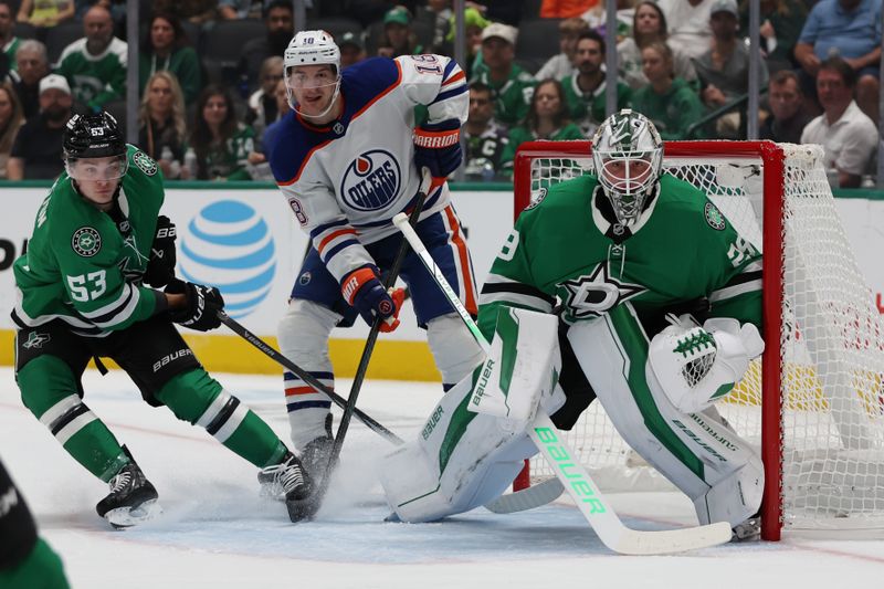 Oct 19, 2024; Dallas, Texas, USA; Edmonton Oilers left wing Zach Hyman (18) fights for position against Dallas Stars center Wyatt Johnston (53) and goaltender Jake Oettinger (29) in the first period at American Airlines Center. Mandatory Credit: Tim Heitman-Imagn Images