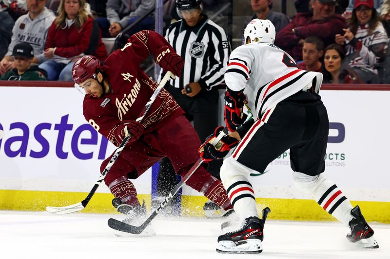 Mar 5, 2024; Tempe, Arizona, USA;  Arizona Coyotes center Nick Schmaltz (8) move the puck against Chicago Blackhawks defenseman Seth Jones (4) during the second period at Mullett Arena. Mandatory Credit: Mark J. Rebilas-USA TODAY Sports