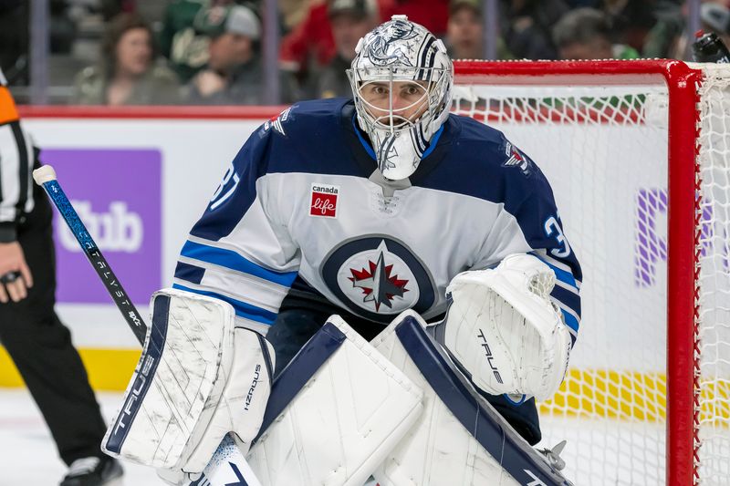 Nov 25, 2024; Saint Paul, Minnesota, USA;  Winnipeg Jets goalie Connor Hellebuyck (37) tracks the play against the Minnesota Wild during the second period at Xcel Energy Center. Mandatory Credit: Nick Wosika-Imagn Images