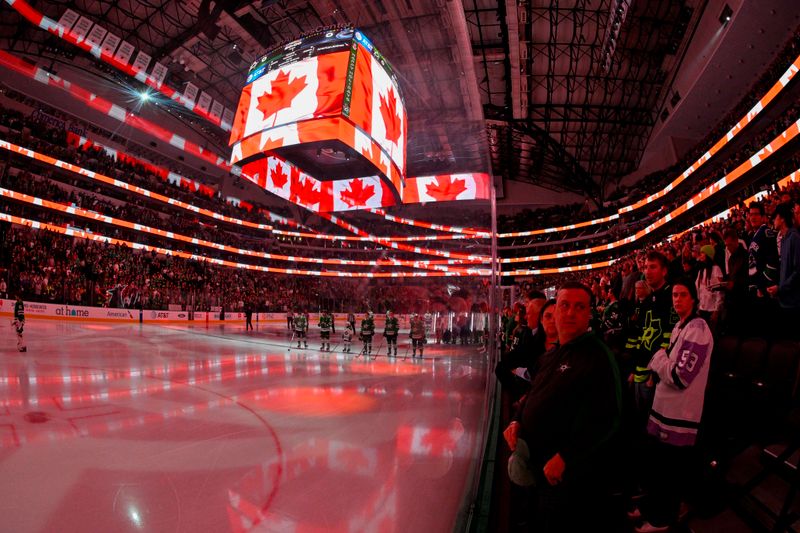 Dec 21, 2023; Dallas, Texas, USA; A view of the players and the ice and the fans and the flag of Canada during the playing of the Canadian national anthem before the game between the Dallas Stars and the Vancouver Canucks at the American Airlines Center. Mandatory Credit: Jerome Miron-USA TODAY Sports