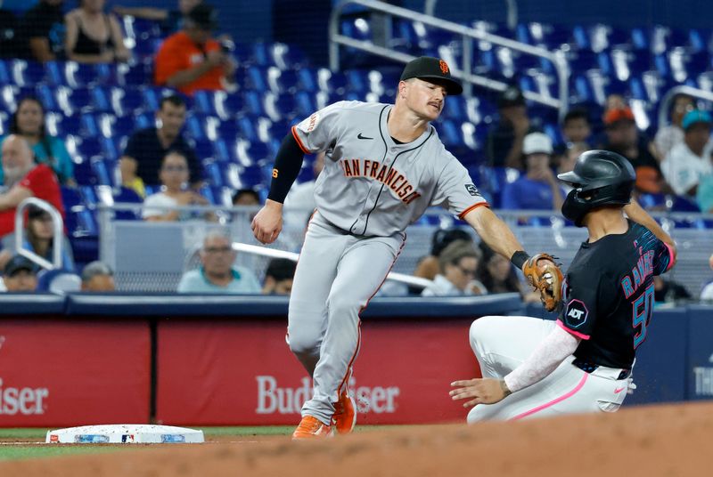 May 31, 2025; Miami, Florida, USA;  Miami Marlins catcher Agustin Ramirez (50) is tagged out by San Francisco Giants third baseman Matt Chapman (26) as he tries to steal third base during the first inning at loanDepot Park. Mandatory Credit: Rhona Wise-Imagn Images