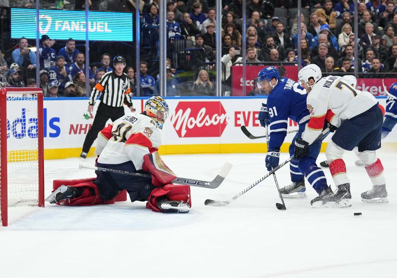 Nov 28, 2023; Toronto, Ontario, CAN; Toronto Maple Leafs center John Tavares (91) battles for the puck with Florida Panthers defenseman Dmitry Kulikov (7) during the third period at Scotiabank Arena. Mandatory Credit: Nick Turchiaro-USA TODAY Sports