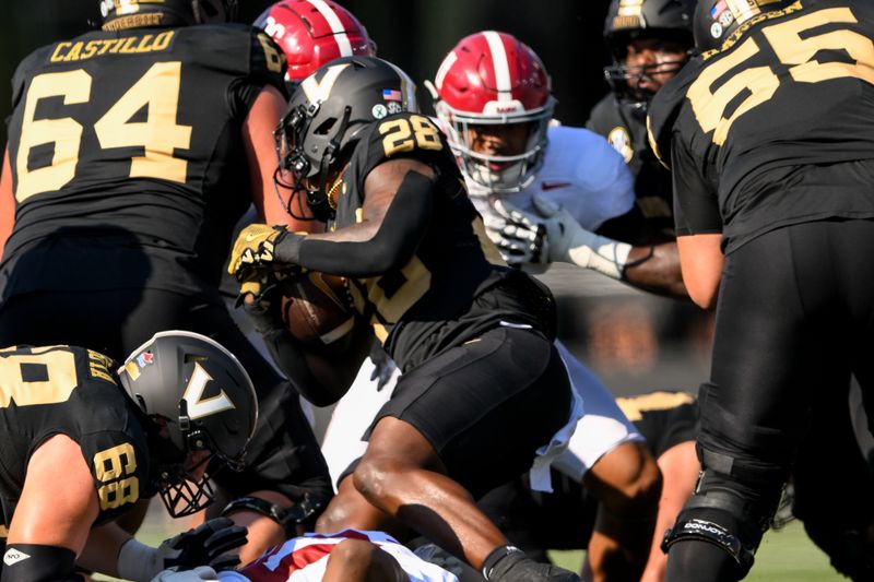 Oct 5, 2024; Nashville, Tennessee, USA;  Vanderbilt Commodores running back Sedrick Alexander (28) gets tackled by Alabama Crimson Tide defensive lineman Jeremiah Beaman (92) during the first half at FirstBank Stadium. Mandatory Credit: Steve Roberts-Imagn Images