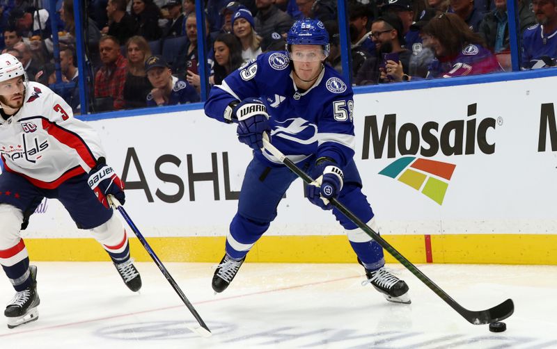 Nov 27, 2024; Tampa, Florida, USA; Tampa Bay Lightning center Jake Guentzel (59) passes the puck as Washington Capitals defenseman Matt Roy (3) defends during the first period at Amalie Arena. Mandatory Credit: Kim Klement Neitzel-Imagn Images