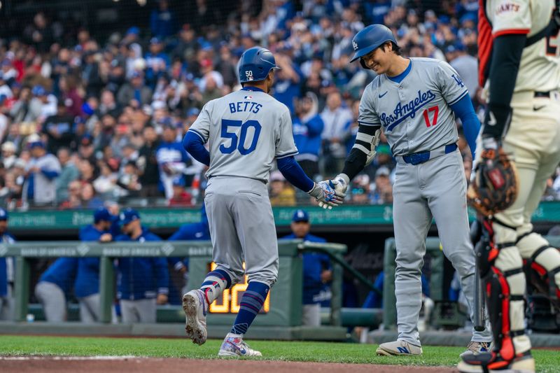 May 13, 2024; San Francisco, California, USA; Los Angeles Dodgers designated hitter Shohei Ohtani (17) and Los Angeles Dodgers shortstop Mookie Betts (50) celebrate after the run against the San Francisco Giants during the first inning at Oracle Park. Mandatory Credit: Neville E. Guard-USA TODAY Sports