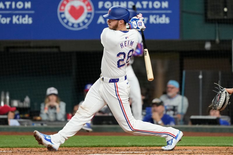 Apr 24, 2024; Arlington, Texas, USA; Texas Rangers catcher Jonah Heim (28) hits a single against the Seattle Mariners during the fourth inning at Globe Life Field. Mandatory Credit: Jim Cowsert-USA TODAY Sports