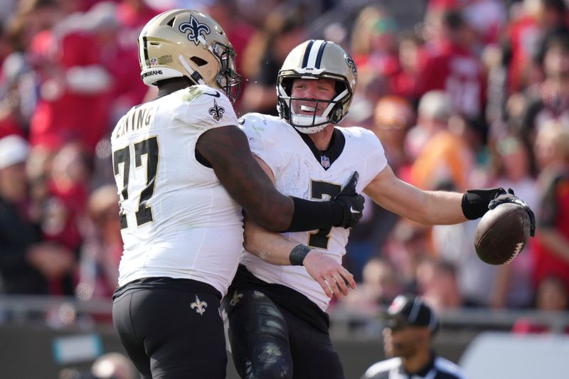 New Orleans Saints quarterback Taysom Hill (7) celebrates his touchdown catch with New Orleans Saints guard Cameron Erving (77) during an NFL football game against the Tampa Bay Buccaneers, Sunday, Dec. 31, 2023, in Tampa, Fla. (AP Photo/Peter Joneleit)