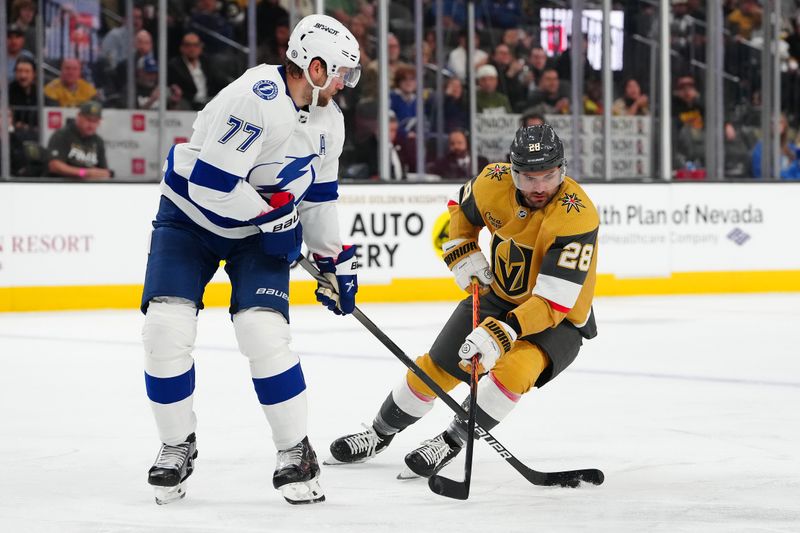 Mar 19, 2024; Las Vegas, Nevada, USA; Tampa Bay Lightning defenseman Victor Hedman (77) clears the puck away from Vegas Golden Knights left wing William Carrier (28) during the second period at T-Mobile Arena. Mandatory Credit: Stephen R. Sylvanie-USA TODAY Sports