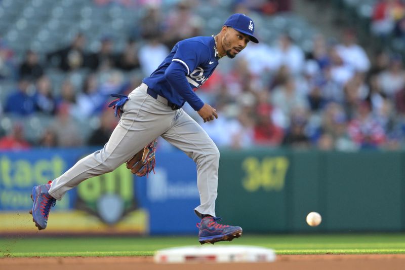 Mar 26, 2024; Anaheim, California, USA;  Los Angeles Angels center fielder Aaron Hicks (12) hits a RBI double past Los Angeles Dodgers shortstop Mookie Betts (50) in the first inning at Angel Stadium. Mandatory Credit: Jayne Kamin-Oncea-USA TODAY Sports