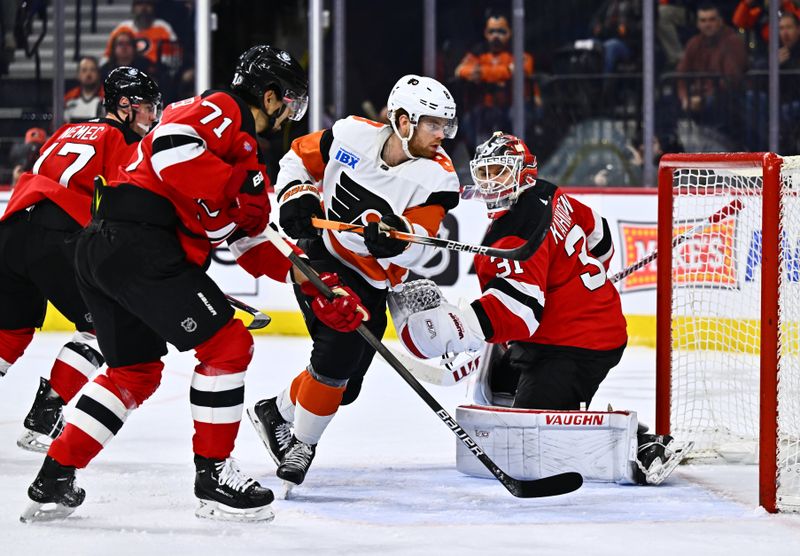 Apr 13, 2024; Philadelphia, Pennsylvania, USA; Philadelphia Flyers defenseman Cam York (8) chases the puck through the crease against New Jersey Devils goalie Kaapo Kahkonen (31) in the first period at Wells Fargo Center. Mandatory Credit: Kyle Ross-USA TODAY Sports