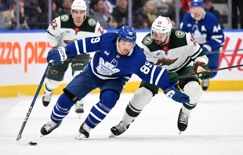 Jan 29, 2025; Toronto, Ontario, CAN;  Toronto Maple Leafs   forward Nick Robertson (89) skates with the puck against Minnesota Wild forward Devin Shore (19) in the first period at Scotiabank Arena. Mandatory Credit: Dan Hamilton-Imagn Images