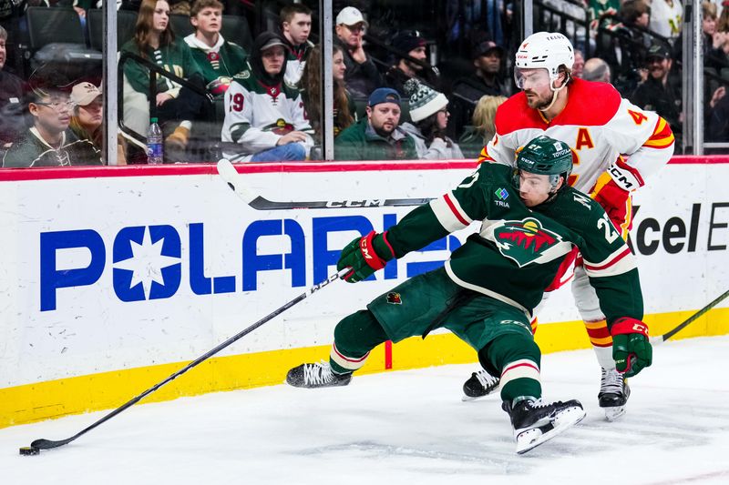 Jan 2, 2024; Saint Paul, Minnesota, USA; Minnesota Wild center Jacob Lucchini (27) is hit by Calgary Flames defenseman Rasmus Andersson (4) during the second period at Xcel Energy Center. Mandatory Credit: Brace Hemmelgarn-USA TODAY Sports