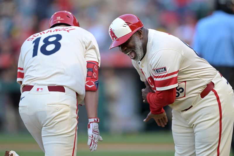 Jun 5, 2024; Anaheim, California, USA;  Los Angeles Angels first baseman Nolan Schanuel (18) is congratulated by third base coach Eric Young Sr. (85) as he rounds the bases after hitting a lead off solo home run in the first inning against the San Diego Padres at Angel Stadium. Mandatory Credit: Jayne Kamin-Oncea-USA TODAY Sports