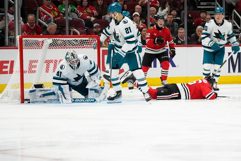 Oct 17, 2024; Chicago, Illinois, USA; Chicago Blackhawks center Jason Dickinson (16) scores a goal on San Jose Sharks goaltender Vitek Vanecek (41) during the third period at United Center. Mandatory Credit: David Banks-Imagn Images