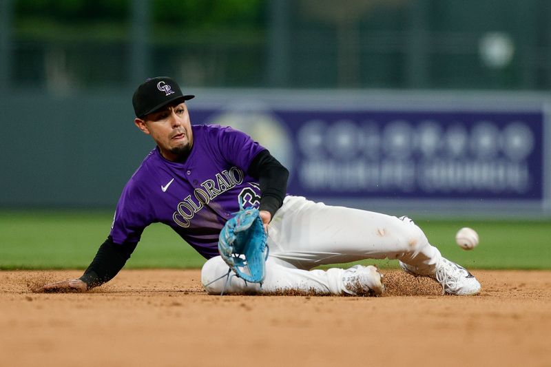 Apr 28, 2025; Denver, Colorado, USA; Colorado Rockies shortstop Alan Trejo (31) fields the ball in the eighth inning against the Atlanta Braves at Coors Field. Mandatory Credit: Isaiah J. Downing-Imagn Images