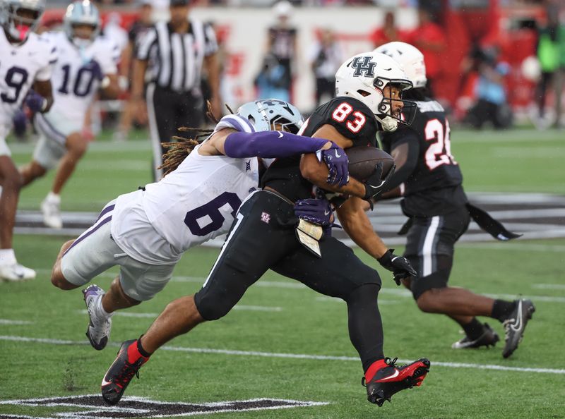 Nov 2, 2024; Houston, Texas, USA; Houston Cougars wide receiver Mekhi Mews (83) breaks a tackle against Kansas State Wildcats safety Jordan Riley (6) in the first quarter at TDECU Stadium. Mandatory Credit: Thomas B. Shea-Imagn Images