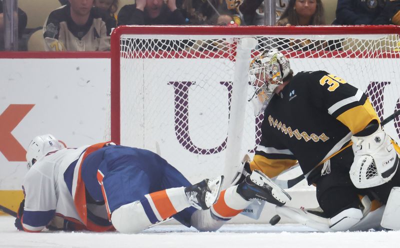 Mar 18, 2025; Pittsburgh, Pennsylvania, USA;  New York Islanders defenseman Noah Dobson (left) scores a goal past Pittsburgh Penguins goaltender Tristan Jarry (35) during the third period at PPG Paints Arena. Mandatory Credit: Charles LeClaire-Imagn Images