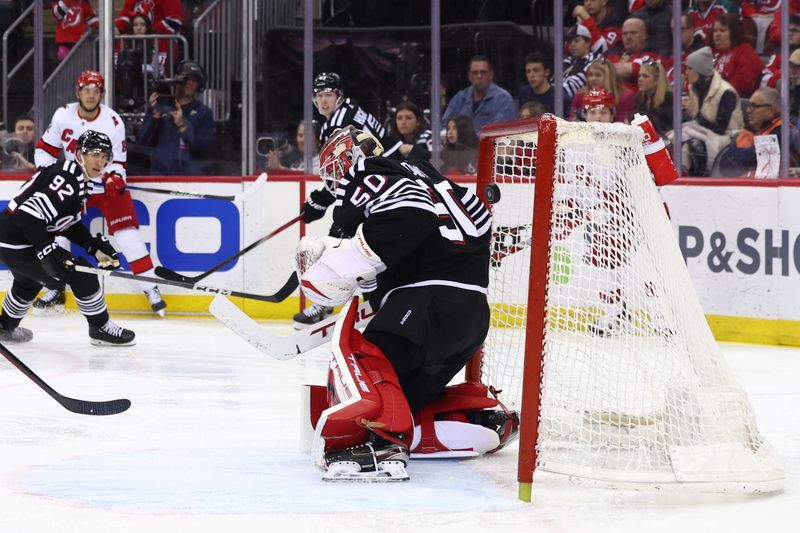 Mar 9, 2024; Newark, New Jersey, USA; Carolina Hurricanes center Jesperi Kotkaniemi (82) scores a goal on New Jersey Devils goaltender Nico Daws (50) during the third period at Prudential Center. Mandatory Credit: Ed Mulholland-USA TODAY Sports