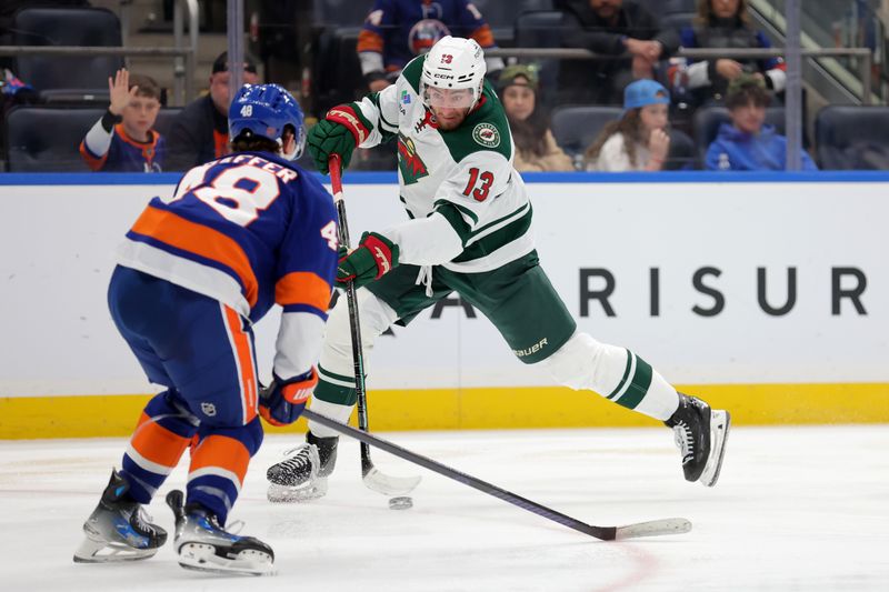 Nov 7, 2025; Elmont, New York, USA; Minnesota Wild center Yakov Trenin (13) takes a shot against New York Islanders defenseman Matthew Schaefer (48) during the third period at UBS Arena. Mandatory Credit: Brad Penner-Imagn Images
