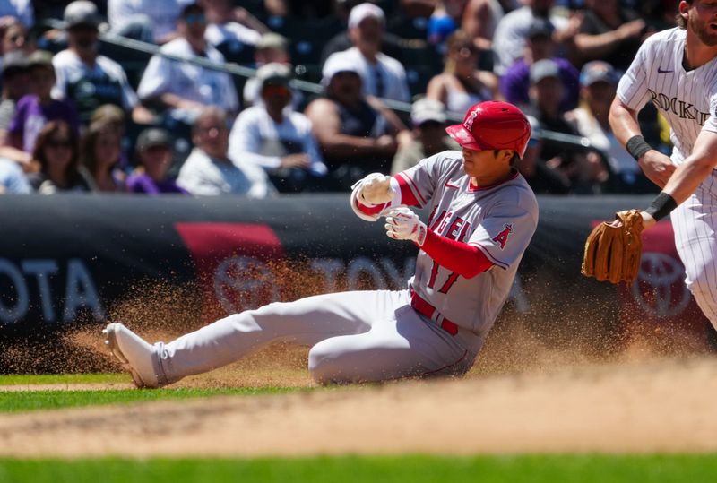 Jun 25, 2023; Denver, Colorado, USA;  Los Angeles Angels starting pitcher Shohei Ohtani (17) slides past the reach of Colorado Rockies third baseman Ryan McMahon (24) after hitting a triple in the sixth inning at Coors Field. Mandatory Credit: Ron Chenoy-USA TODAY Sports