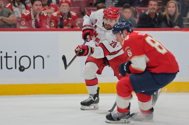 Nov 30, 2024; Sunrise, Florida, USA; Carolina Hurricanes left wing William Carrier (28) shoots the puck against the Florida Panthers during the first period at Amerant Bank Arena. Mandatory Credit: Sam Navarro-Imagn Images