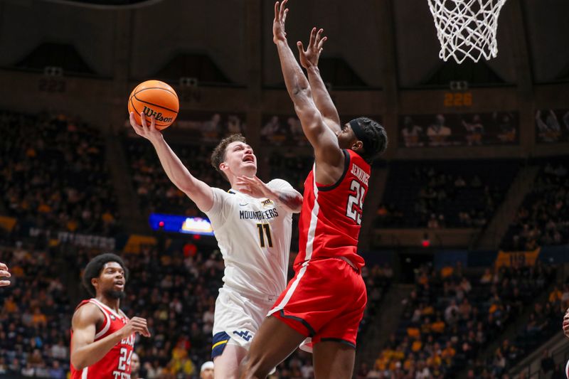 Mar 2, 2024; Morgantown, West Virginia, USA; West Virginia Mountaineers forward Quinn Slazinski (11) shoots in the lane against Texas Tech Red Raiders forward Robert Jennings (25) during the second half at WVU Coliseum. Mandatory Credit: Ben Queen-USA TODAY Sports