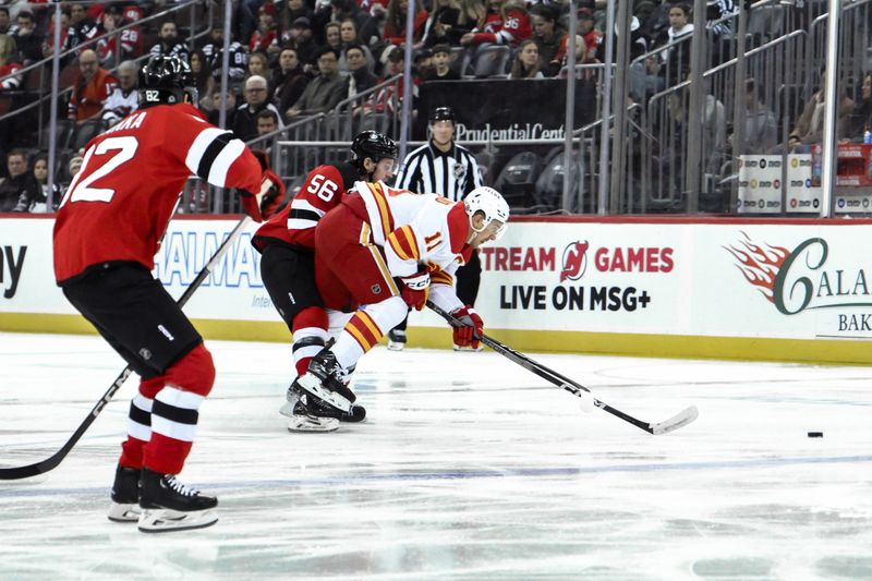 Feb 8, 2024; Newark, New Jersey, USA; Calgary Flames center Mikael Backlund (11) skates with the puck against New Jersey Devils left wing Erik Haula (56) during the first period at Prudential Center. Mandatory Credit: John Jones-USA TODAY Sports