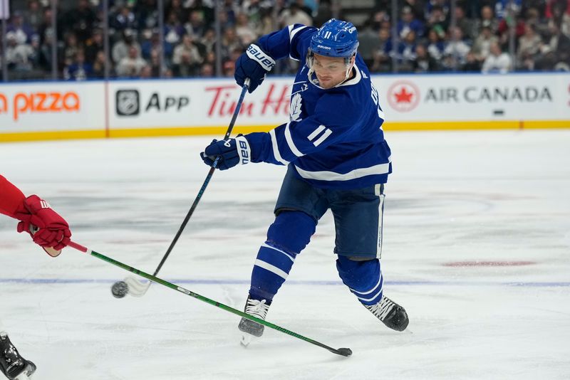 Nov 8, 2024; Toronto, Ontario, CAN; Toronto Maple Leafs forward Max Domi (11) shoots the puck against the Detroit Red Wings during the third period at Scotiabank Arena. Mandatory Credit: John E. Sokolowski-Imagn Images