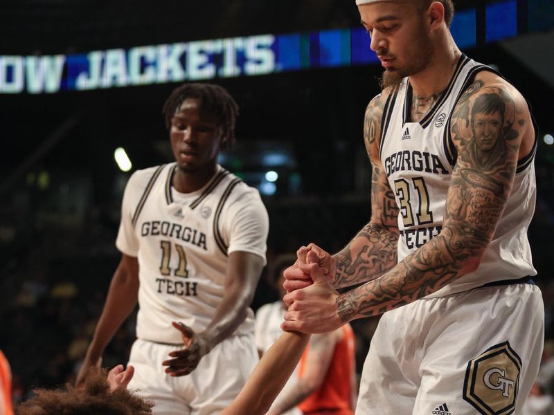 Jan 14, 2025; Atlanta, Georgia, USA; Georgia Tech Yellow Jackets forward Baye Ndongo (11) and forward Duncan Powell (31) help up teammate guard Naithan George (1) in the game against the Clemson Tigers during the second half at McCamish Pavilion. Mandatory Credit: Jordan Godfree-Imagn Images