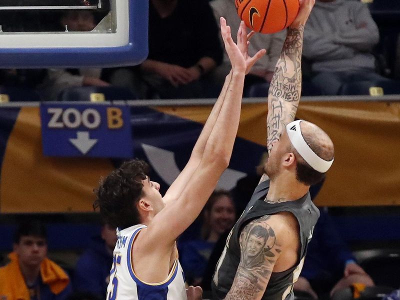 Feb 25, 2025; Pittsburgh, Pennsylvania, USA;  Pittsburgh Panthers forward Guillermo Diaz Graham (25) blocks a shot by Georgia Tech Yellow Jackets forward Duncan Powell (right) during the first half at the Petersen Events Center. Mandatory Credit: Charles LeClaire-Imagn Images