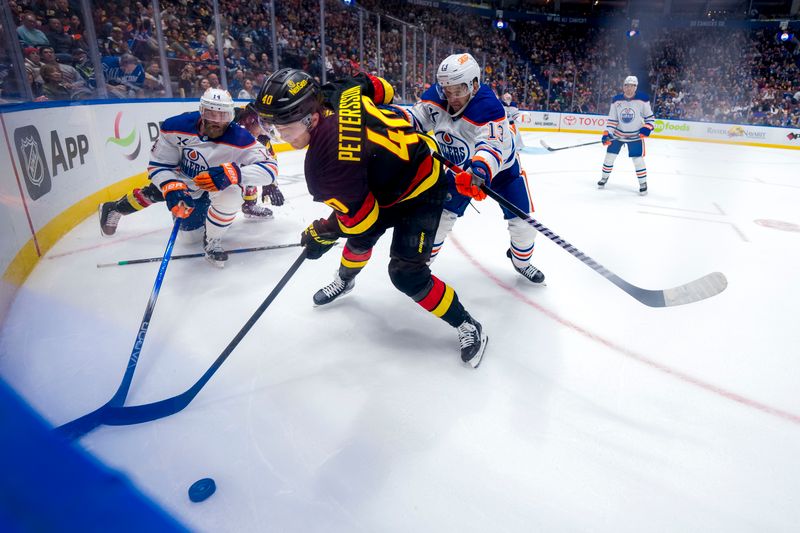 Nov 9, 2024; Vancouver, British Columbia, CAN; Edmonton Oilers defenseman Mattias Ekholm (14) and forward Mattias Janmark (13) battle with Vancouver Canucks forward Elias Pettersson (40) during the second period at Rogers Arena. Mandatory Credit: Bob Frid-Imagn Images