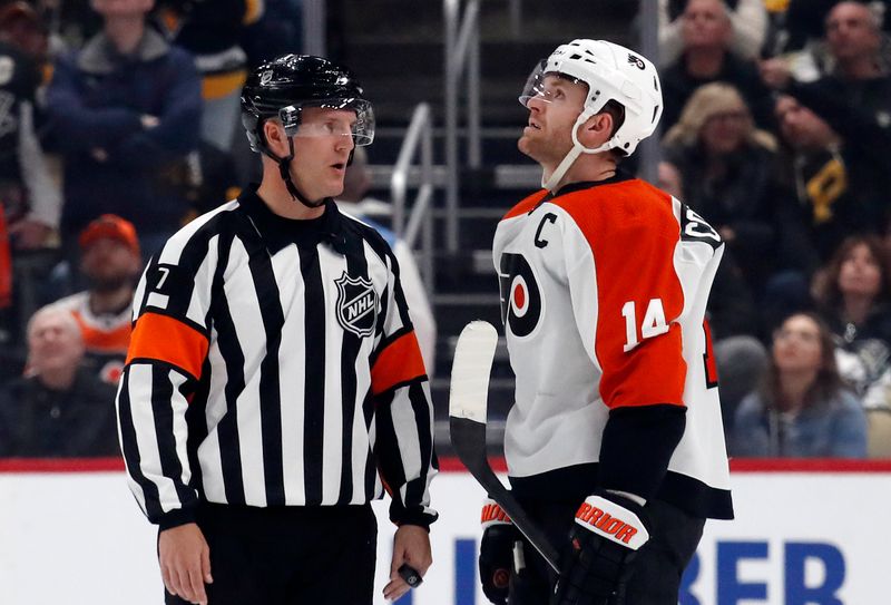 Feb 25, 2024; Pittsburgh, Pennsylvania, USA;  NHL referee Garrett Rank (7) talks with Philadelphia Flyers center Sean Couturier (14) against the Pittsburgh Penguins during the second period at PPG Paints Arena. Mandatory Credit: Charles LeClaire-USA TODAY Sports