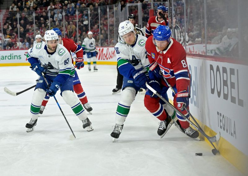 Jan 6, 2025; Montreal, Quebec, CAN; Montreal Canadiens defenseman Mike Matheson (8) plays the puck against Vancouver Canucks forward Danton Heinen (20) and forward Max Sasson (63) during the first period at the Bell Centre. Mandatory Credit: Eric Bolte-Imagn Images