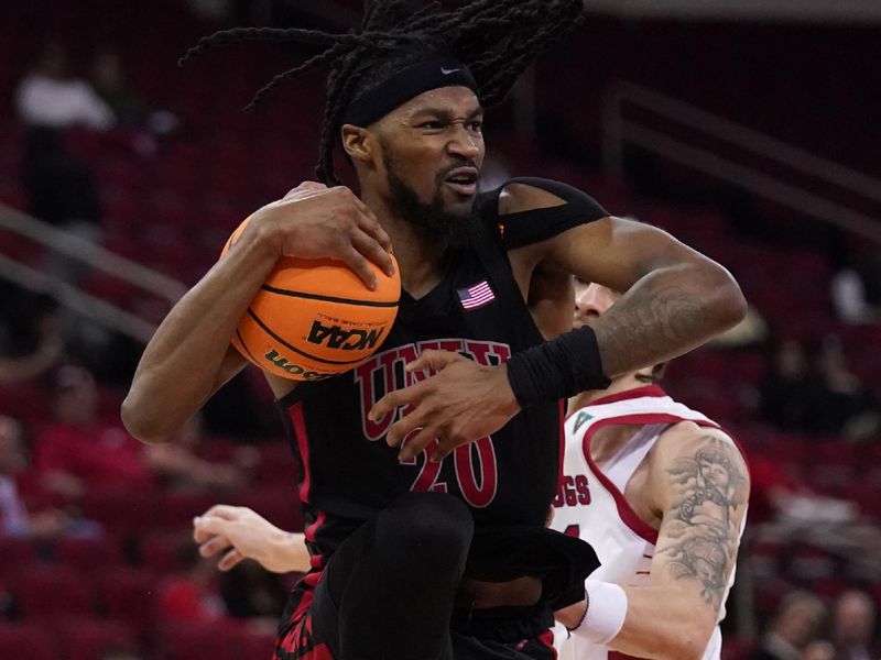 Feb 14, 2024; Fresno, California, USA; UNLV Rebels forward Keylan Boone (20) holds onto a rebound in front of Fresno State Bulldogs guard Isaiah Pope (21) in the second half at the Save Mart Center. Mandatory Credit: Cary Edmondson-USA TODAY Sports