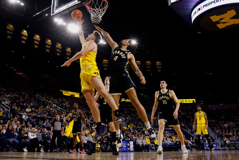 Feb 25, 2024; Ann Arbor, Michigan, USA;  Michigan Wolverines forward Will Tschetter (42) shoots on Purdue Boilermakers forward Trey Kaufman-Renn (4) in the first half at Crisler Center. Mandatory Credit: Rick Osentoski-USA TODAY Sports