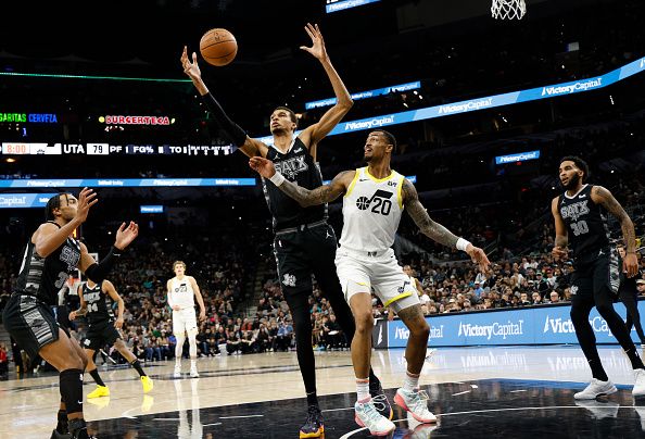 SAN ANTONIO, TX - DECEMBER 26:  Victor Wembanyama #1 of the San Antonio Spurs grabs a rebound over John Collins #20 of the Utah Jazz in the first half at Frost Bank Center on December  26, 2023 in San Antonio, Texas. NOTE TO USER: User expressly acknowledges and agrees that, by downloading and or using this photograph, User is consenting to terms and conditions of the Getty Images License Agreement. (Photo by Ronald Cortes/Getty Images)