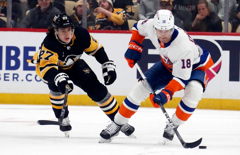 Feb 20, 2024; Pittsburgh, Pennsylvania, USA; New York Islanders left wing Pierre Engvall (18) handles the puck against Pittsburgh Penguins defenseman Ryan Graves (27) during the first period at PPG Paints Arena. Mandatory Credit: Charles LeClaire-USA TODAY Sports